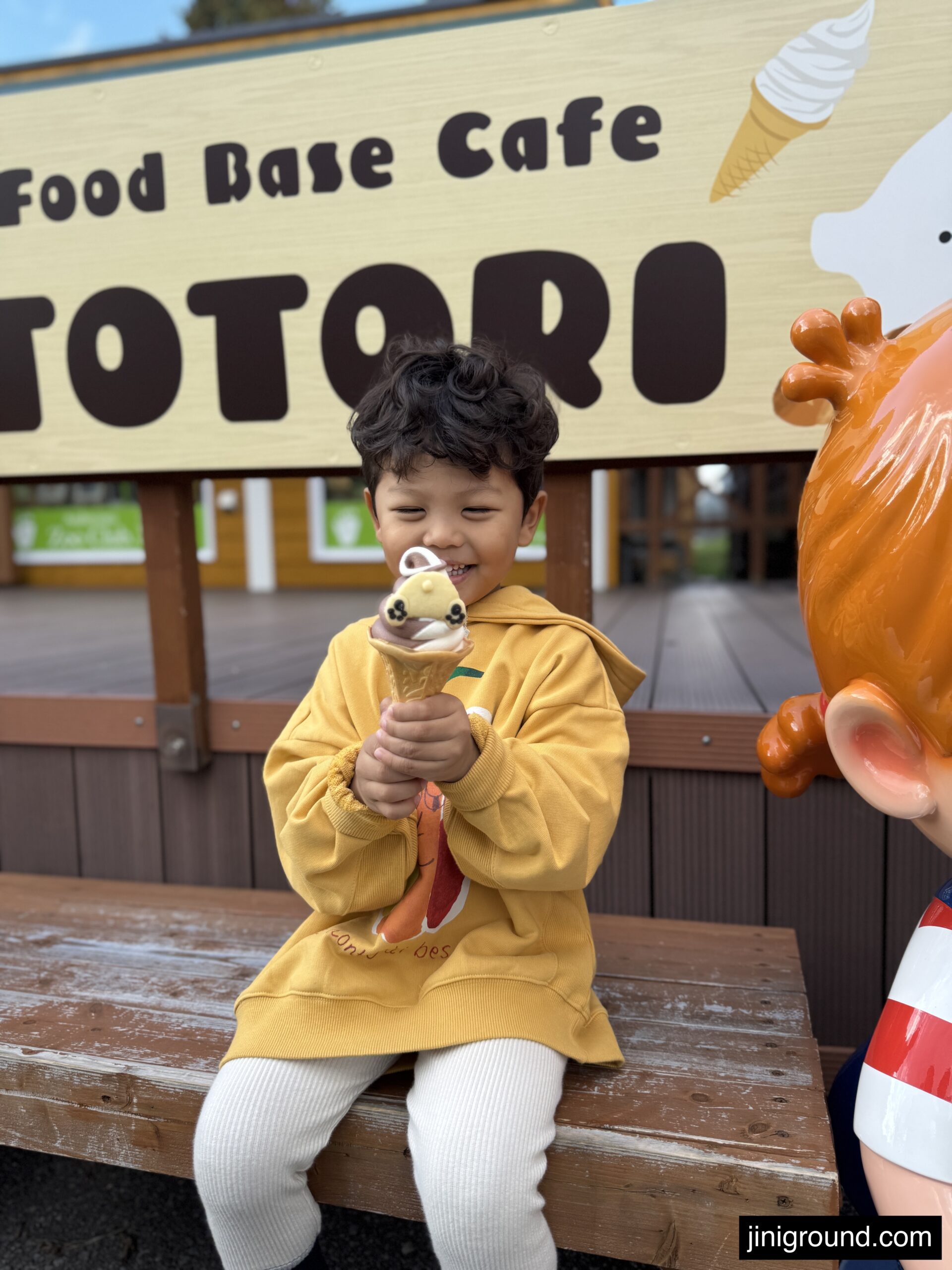 Small child holding ice cream cone at Asahiyama Zoo food base cafe