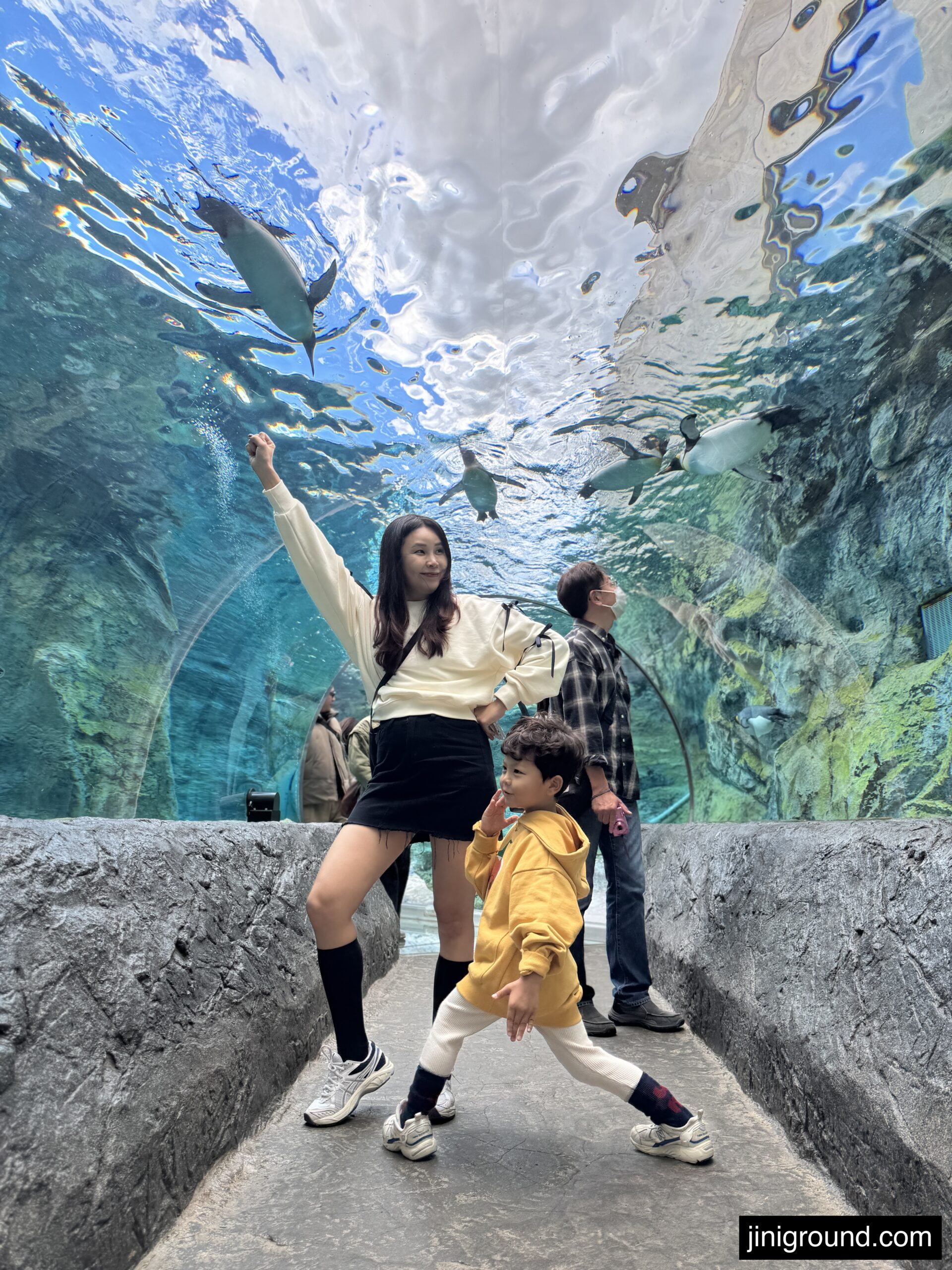 Family walking through underwater tunnel viewing marine life at Asahiyama Zoo