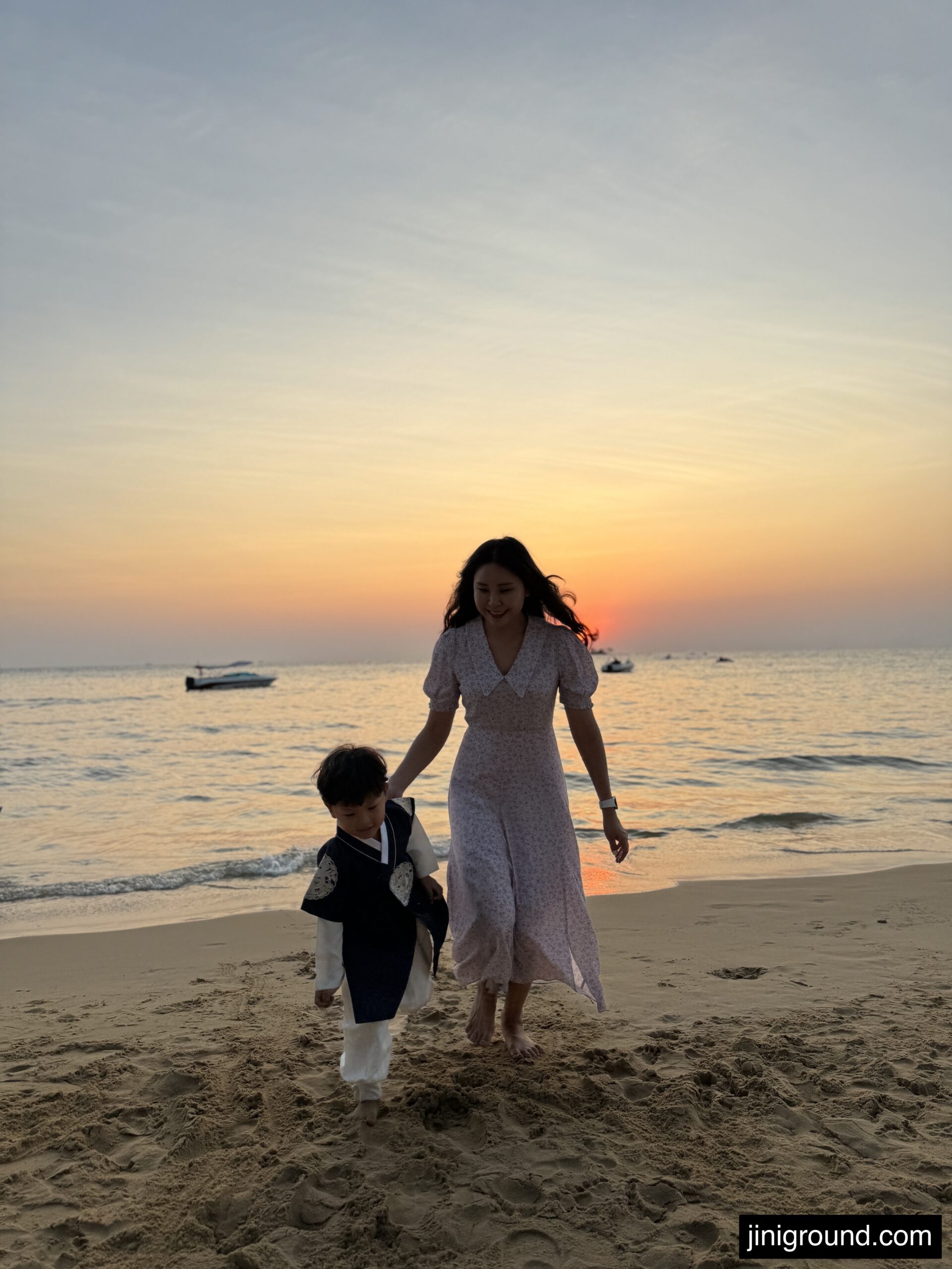 Couple sitting on wooden beach bench at sunset overlooking Phu Quoc ocean