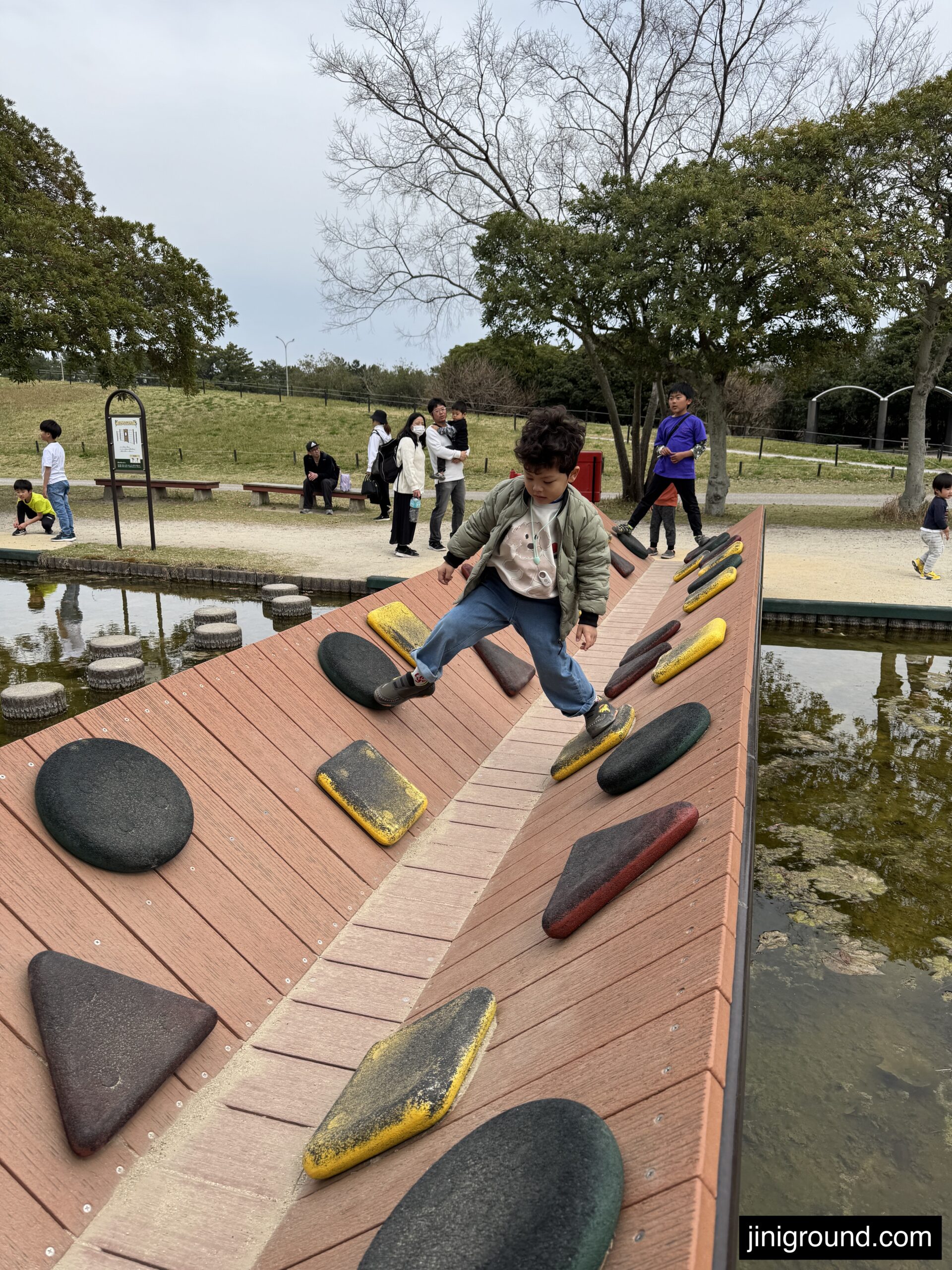 Boy climbing outdoor rock wall at adventure playground in Uminonakamichi Seaside Park Fukuoka