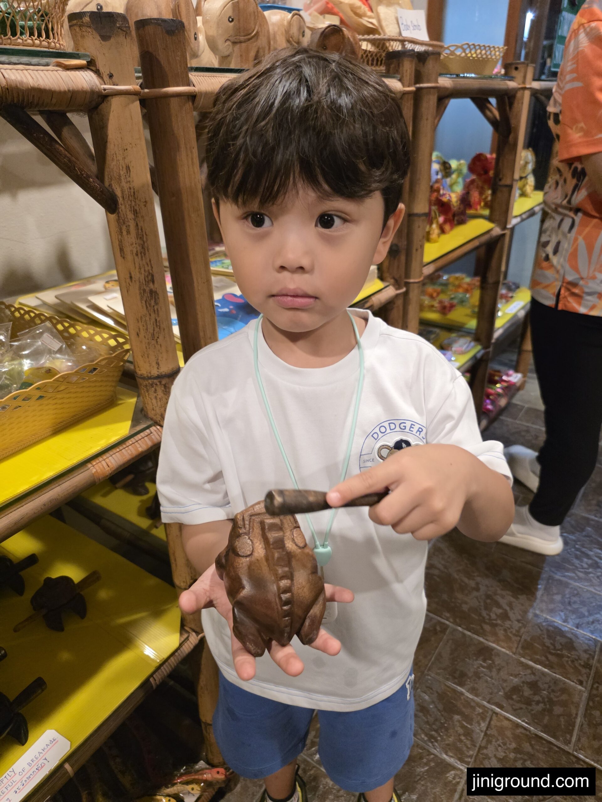 boy holding wooden souvenir at gift shop in Chiang Mai Night Safari