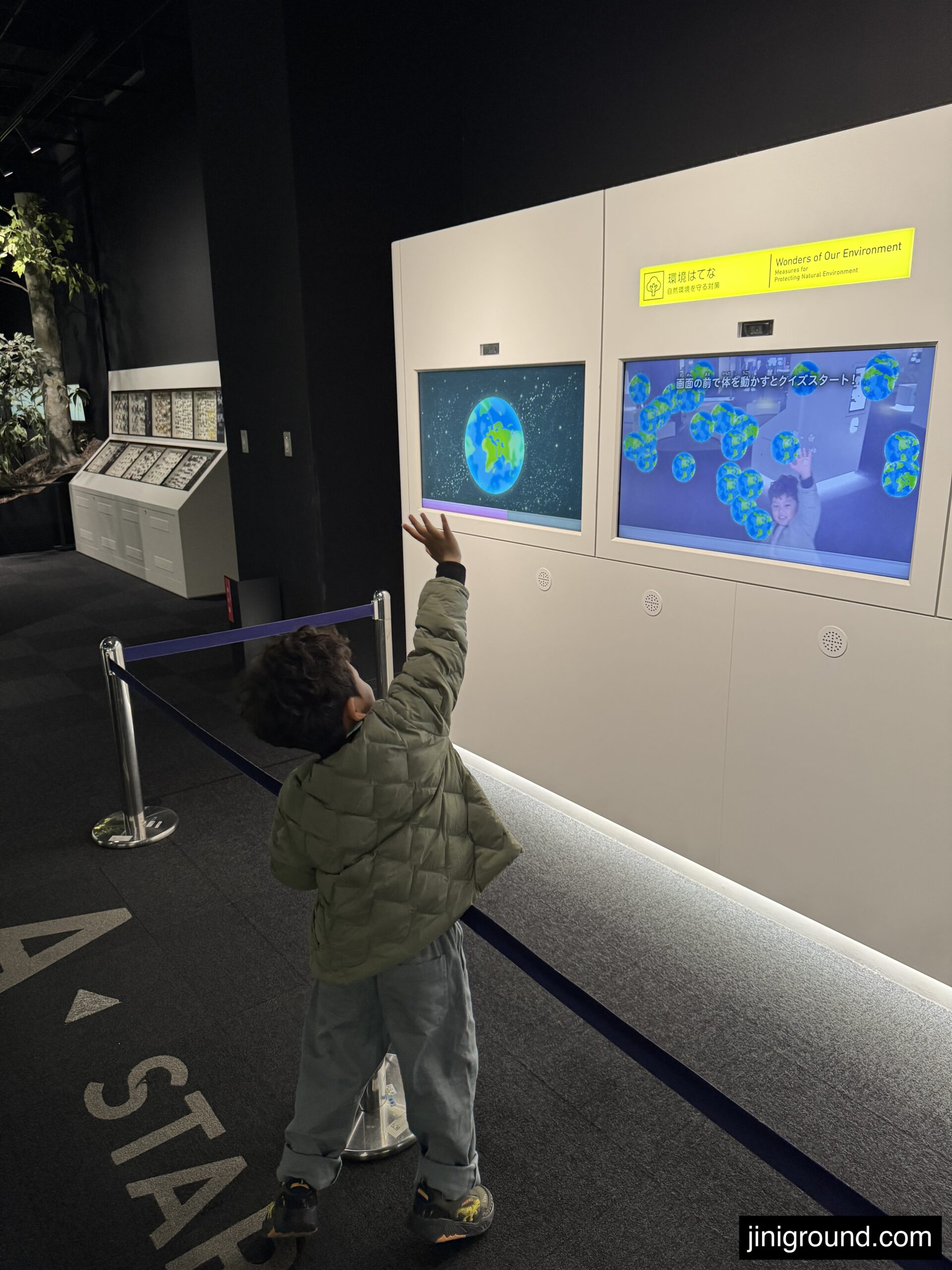 Boy interacting with space and earth themed digital exhibit at Fukuoka Science Museum