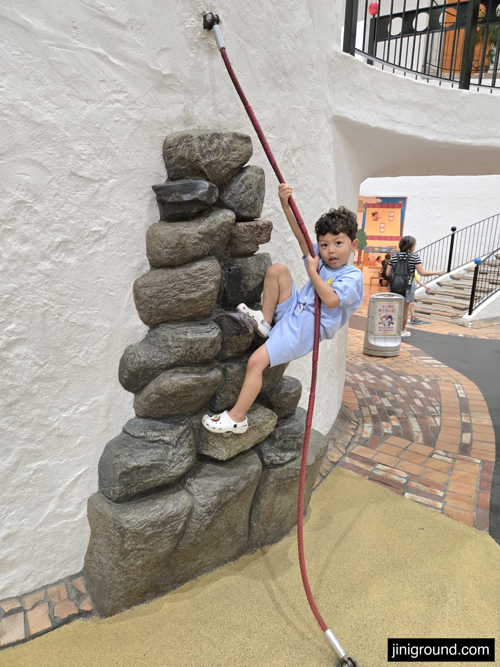 Child climbing rope obstacle course at Osaka Kids Plaza children museum