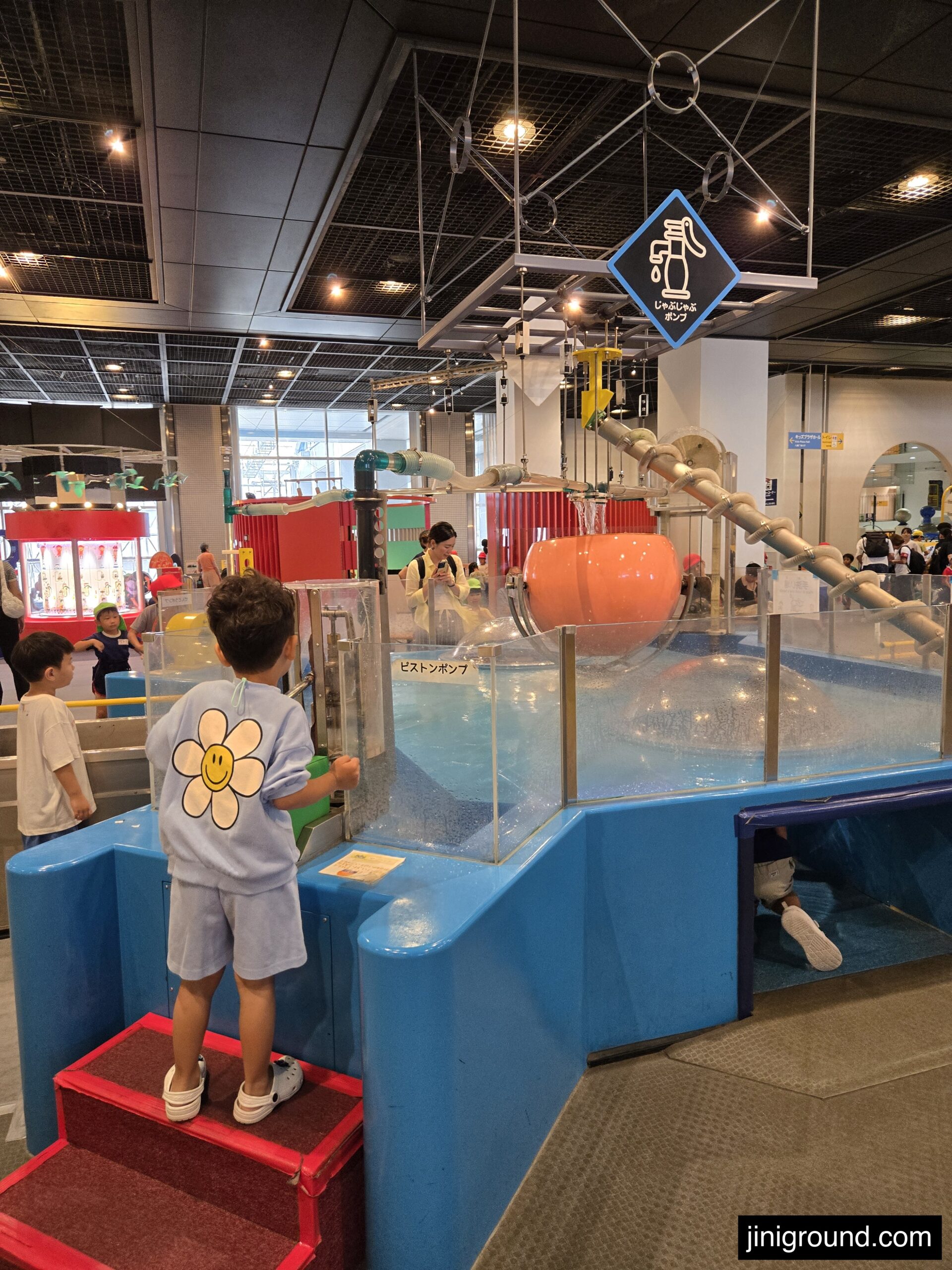 Child enjoying blue slide structure in Osaka Kids Plaza play area Japan