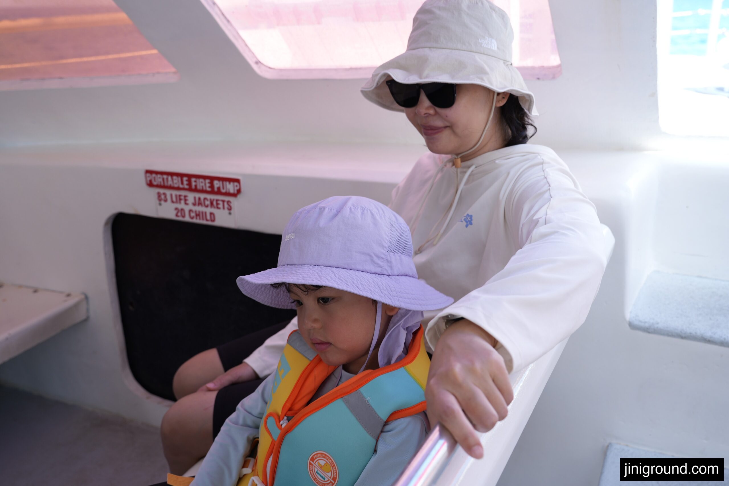 mom and son wearing life jacket inside dolphin cruise boat in Guam