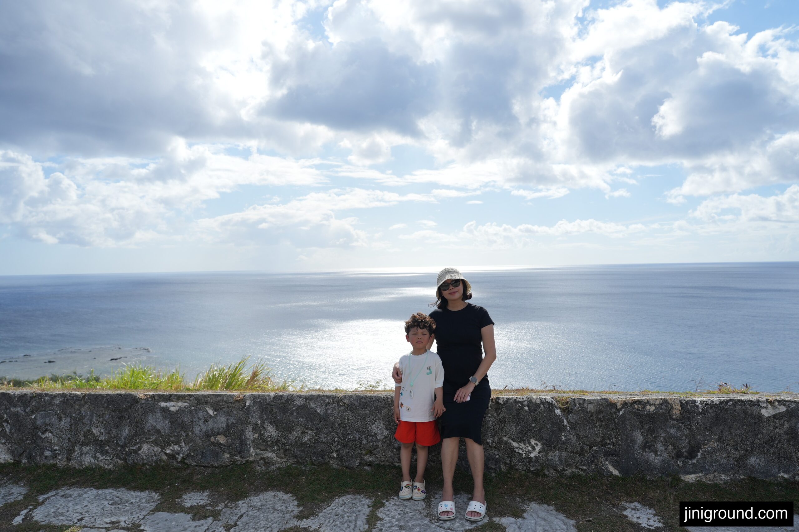 mom and son posing at ocean cliff viewpoint during south Guam rental car tour