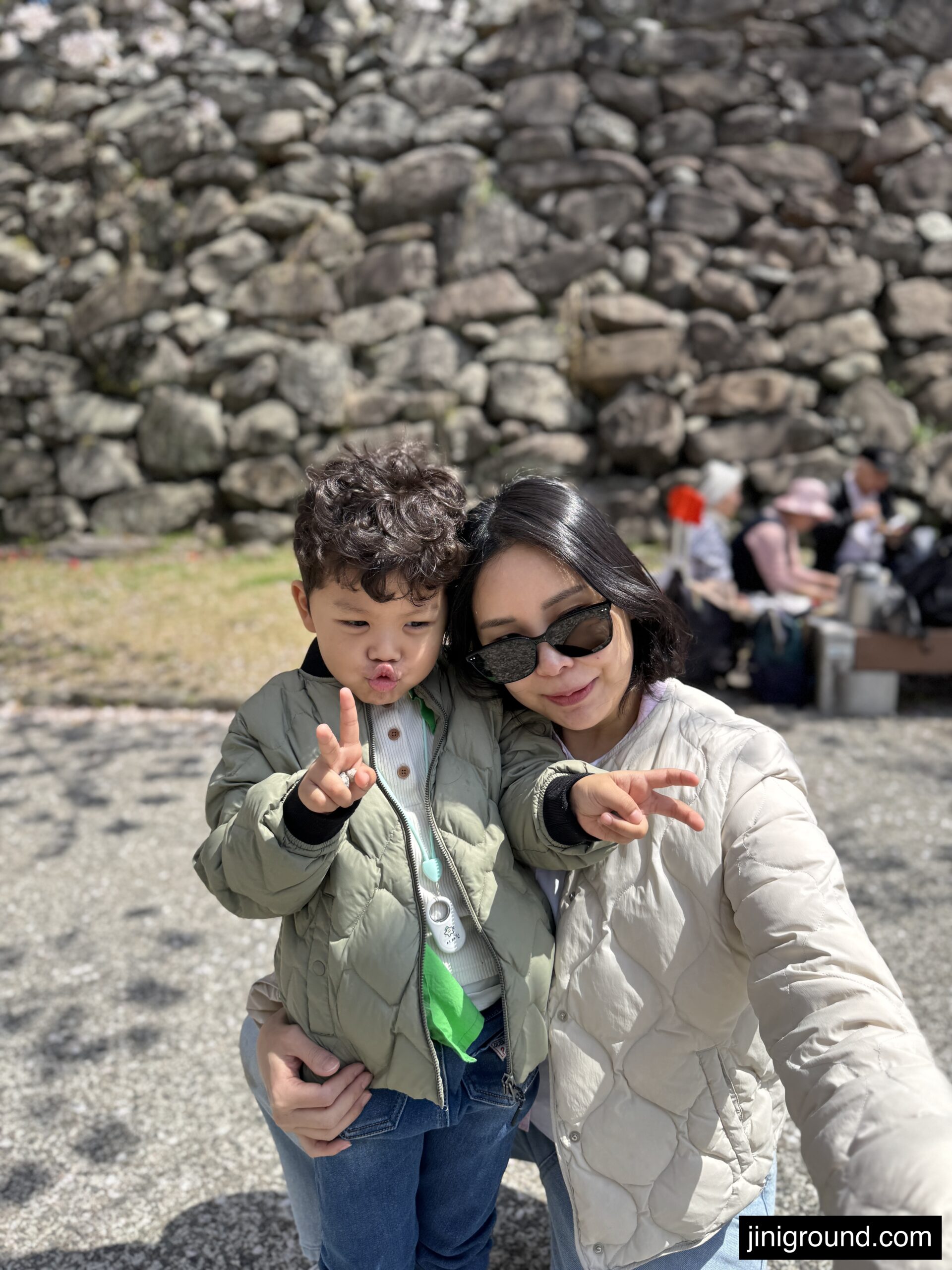 Mom and son taking selfie in front of Fukuoka castle stone wall ruins near Ohori Park