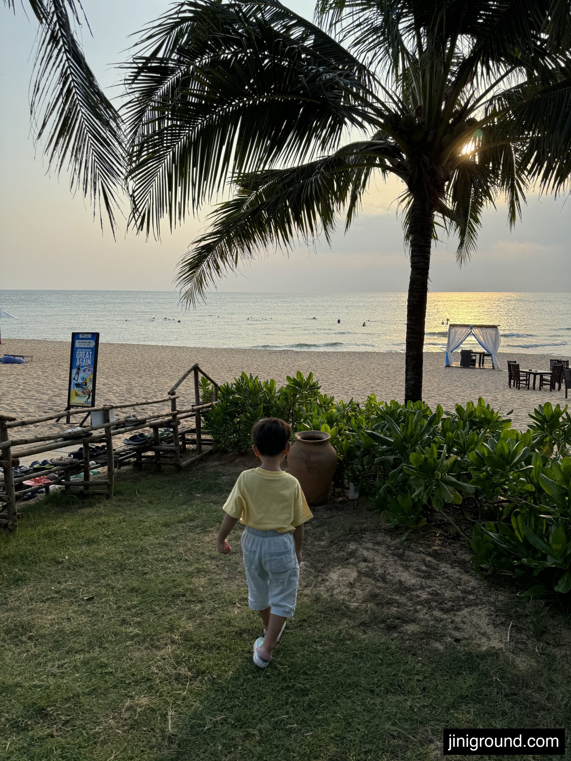 Mother and toddler playing with sand and bucket on Phu Quoc beach