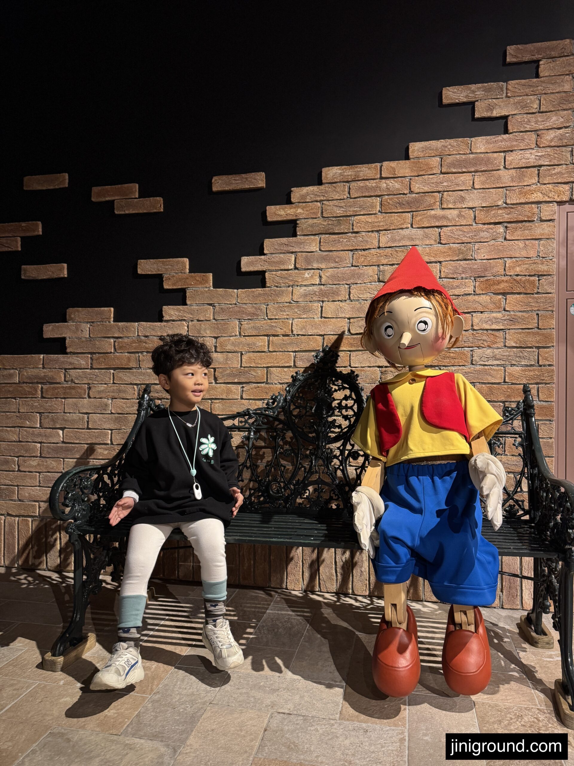 Child near decorated festival entrance with pumpkins and celebration signage