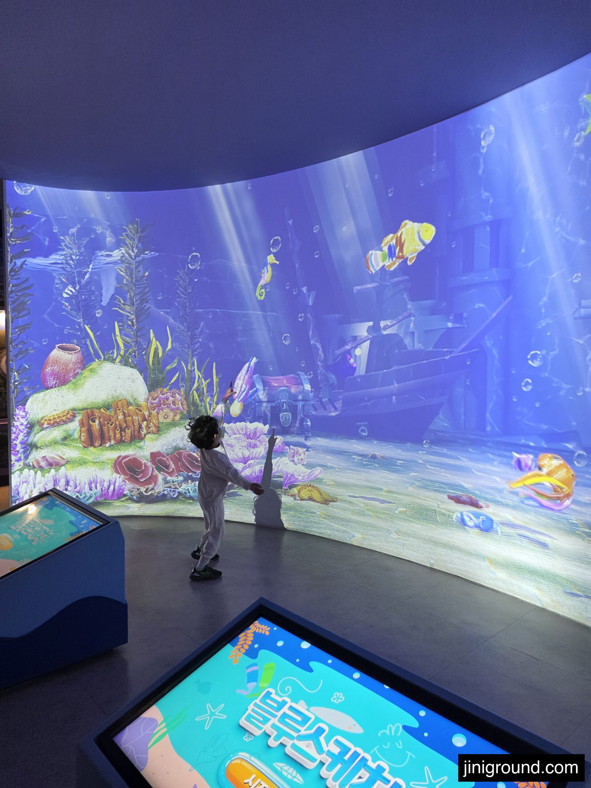 boy playing with interactive ocean projection display at Tongyeong Marine Science Museum