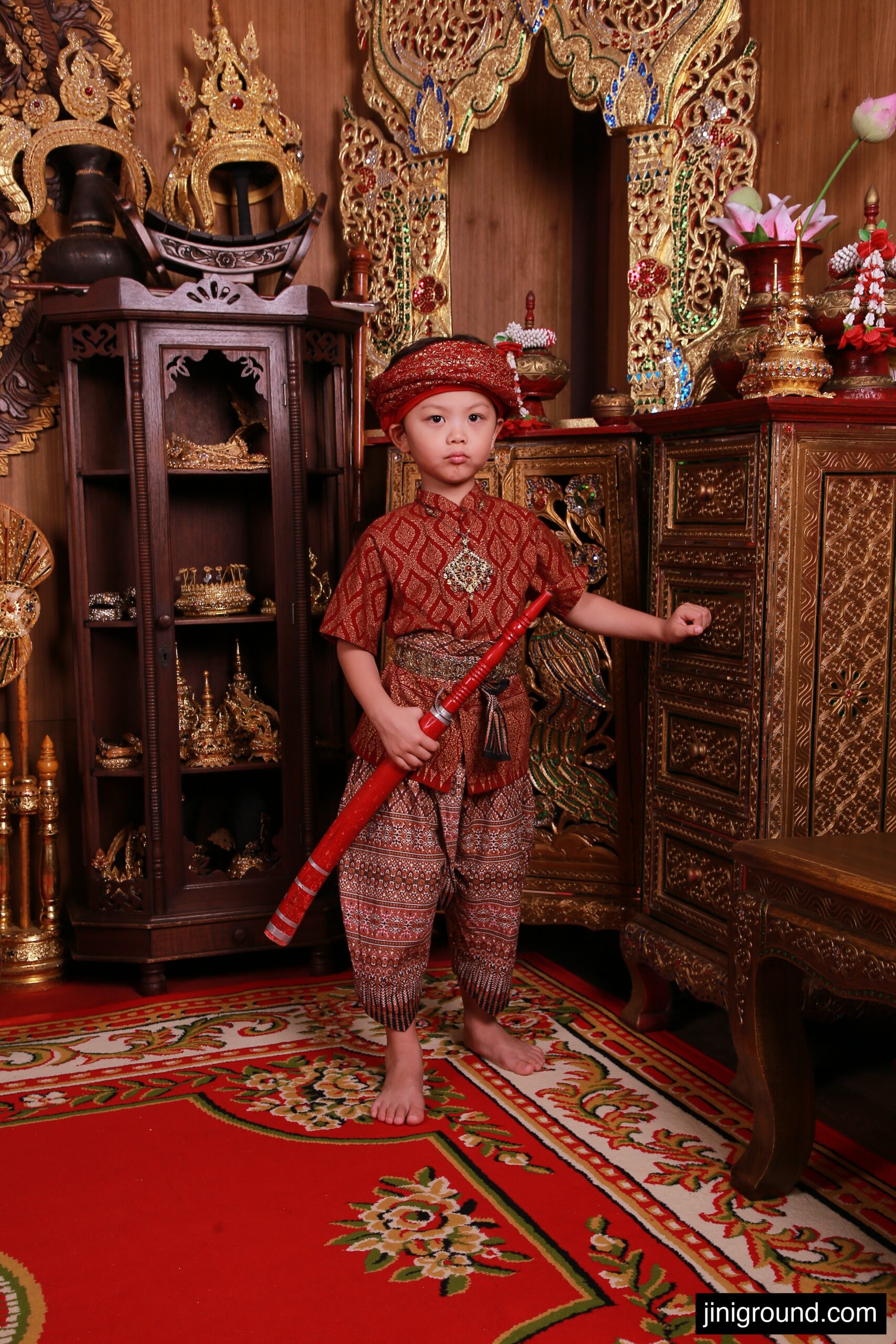 boy in Thai traditional costume sitting on ornate throne retouched photo Nakara Studio