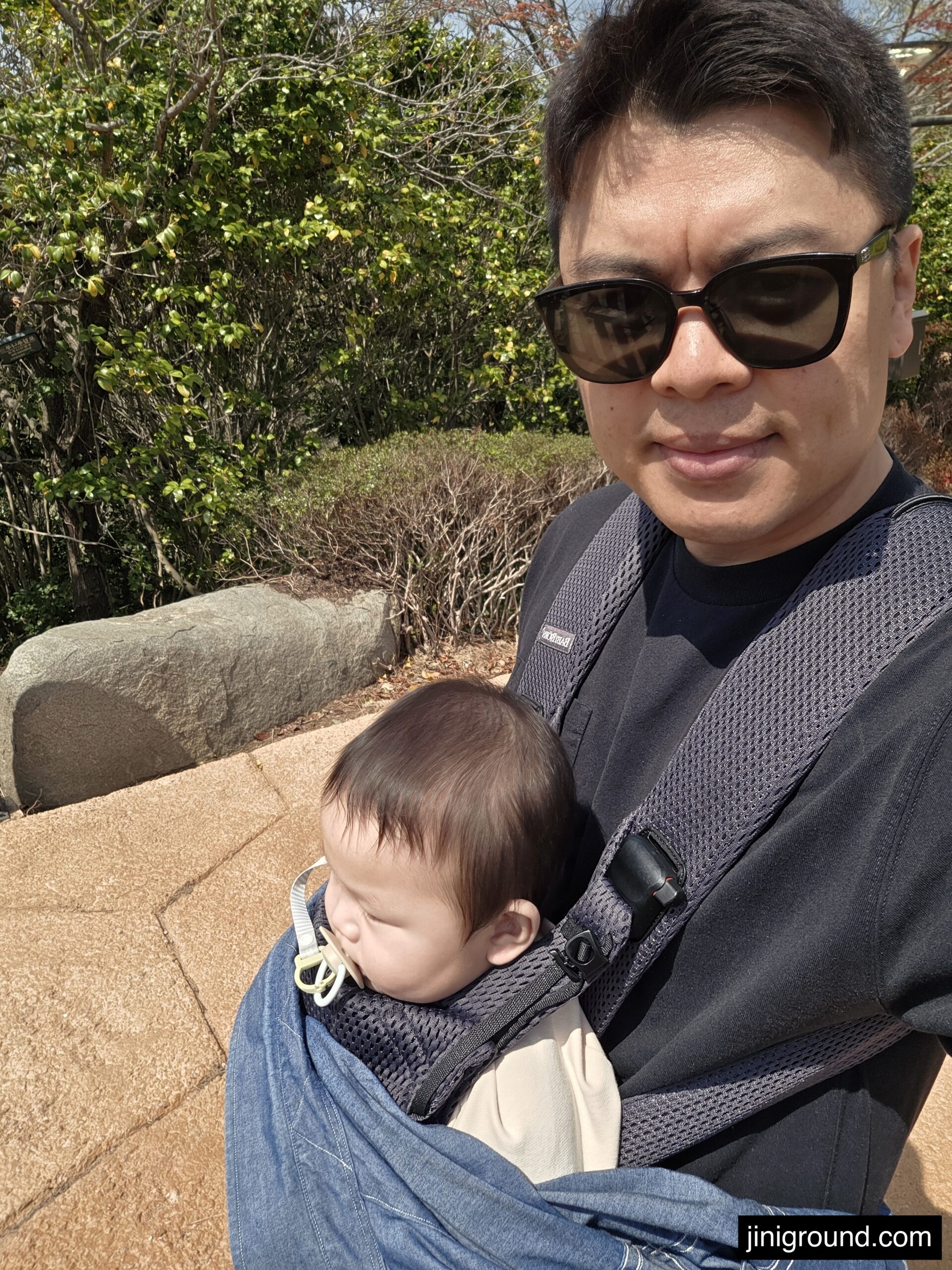 dad carrying sleeping baby in carrier at Dara Park Tongyeong