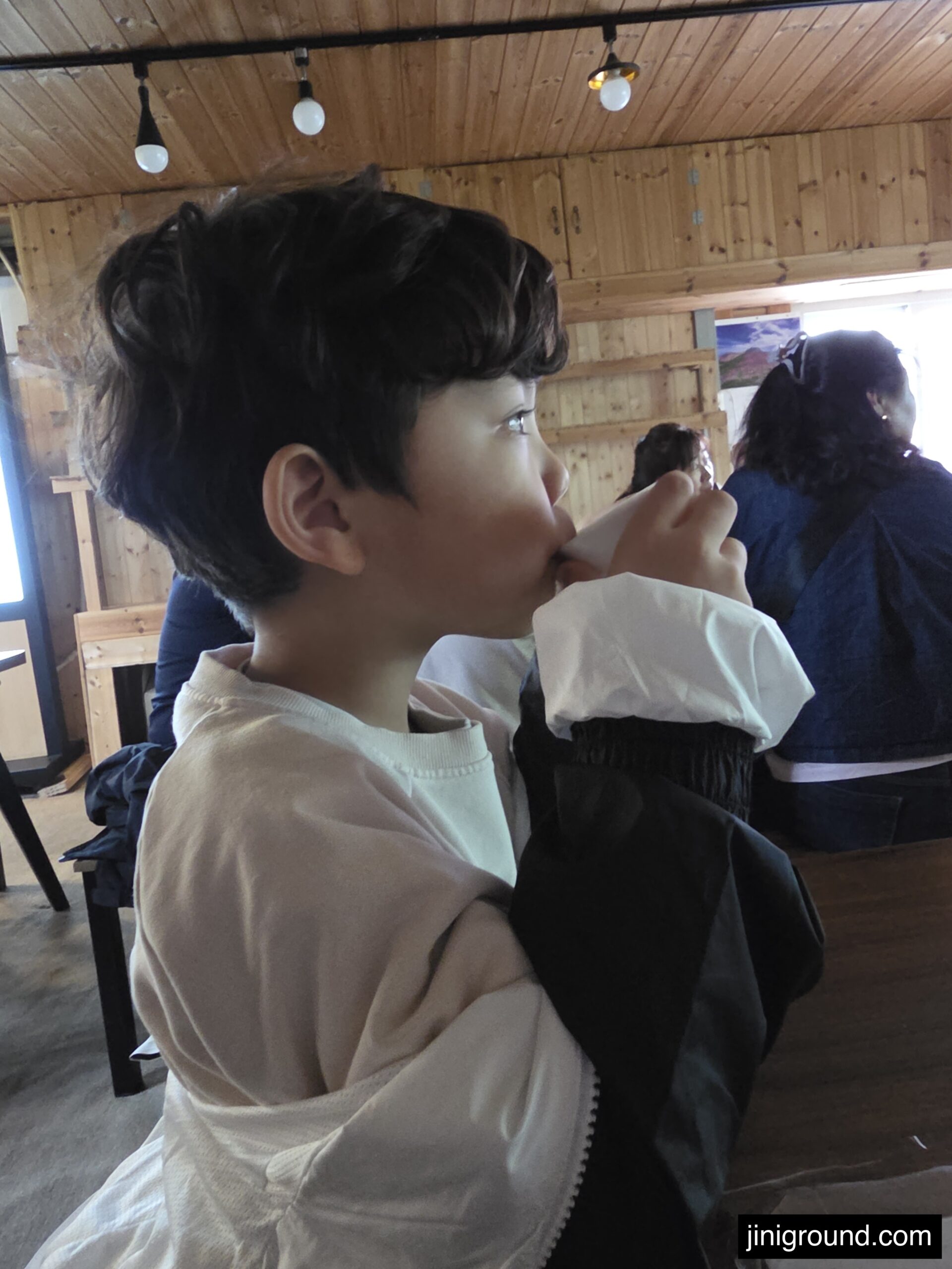 7-year-old boy drinking herbal tea at wooden cabin Napoli Farm Tongyeong