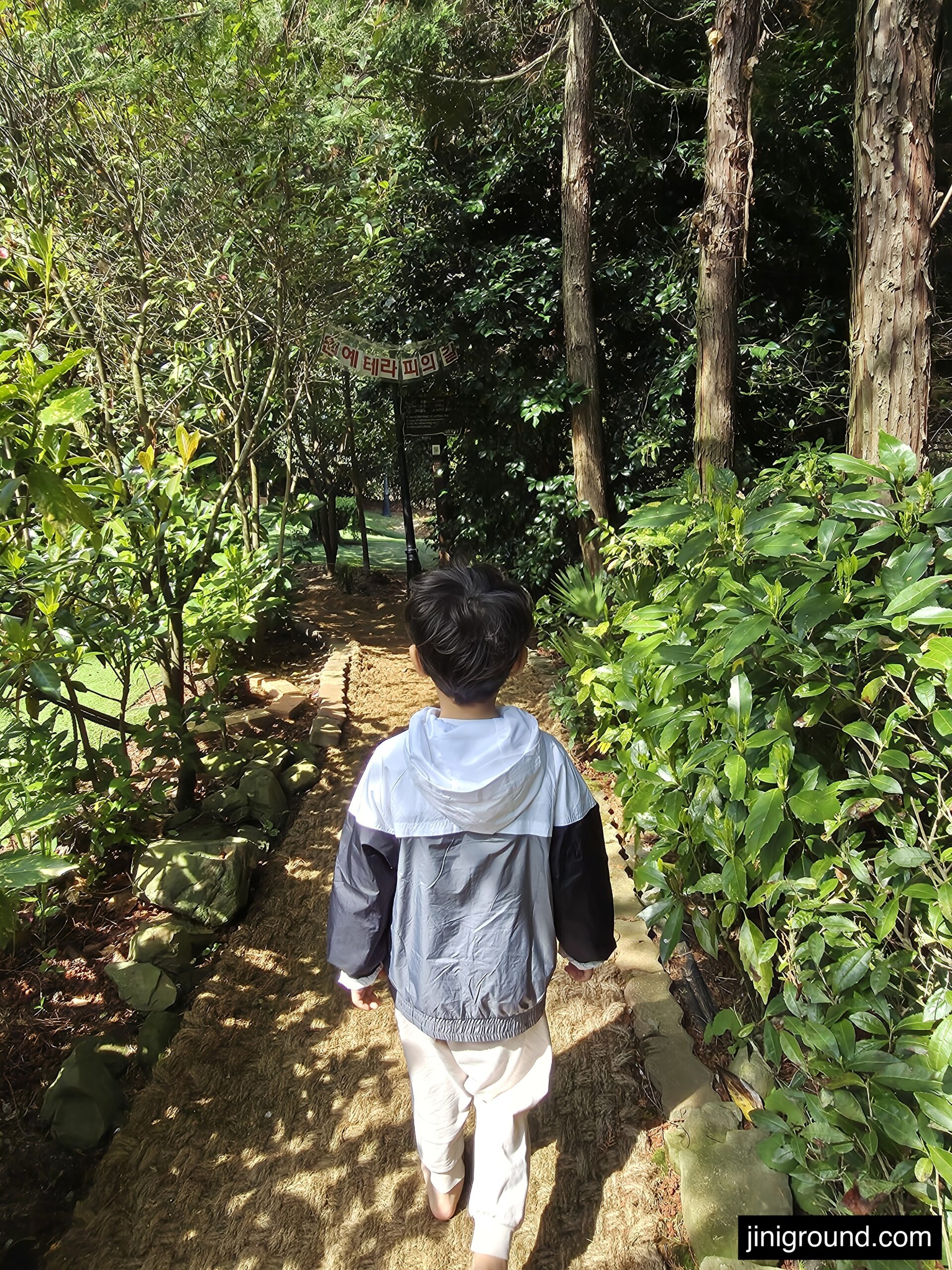 boy walking barefoot on sawdust forest trail at Napoli Farm Tongyeong