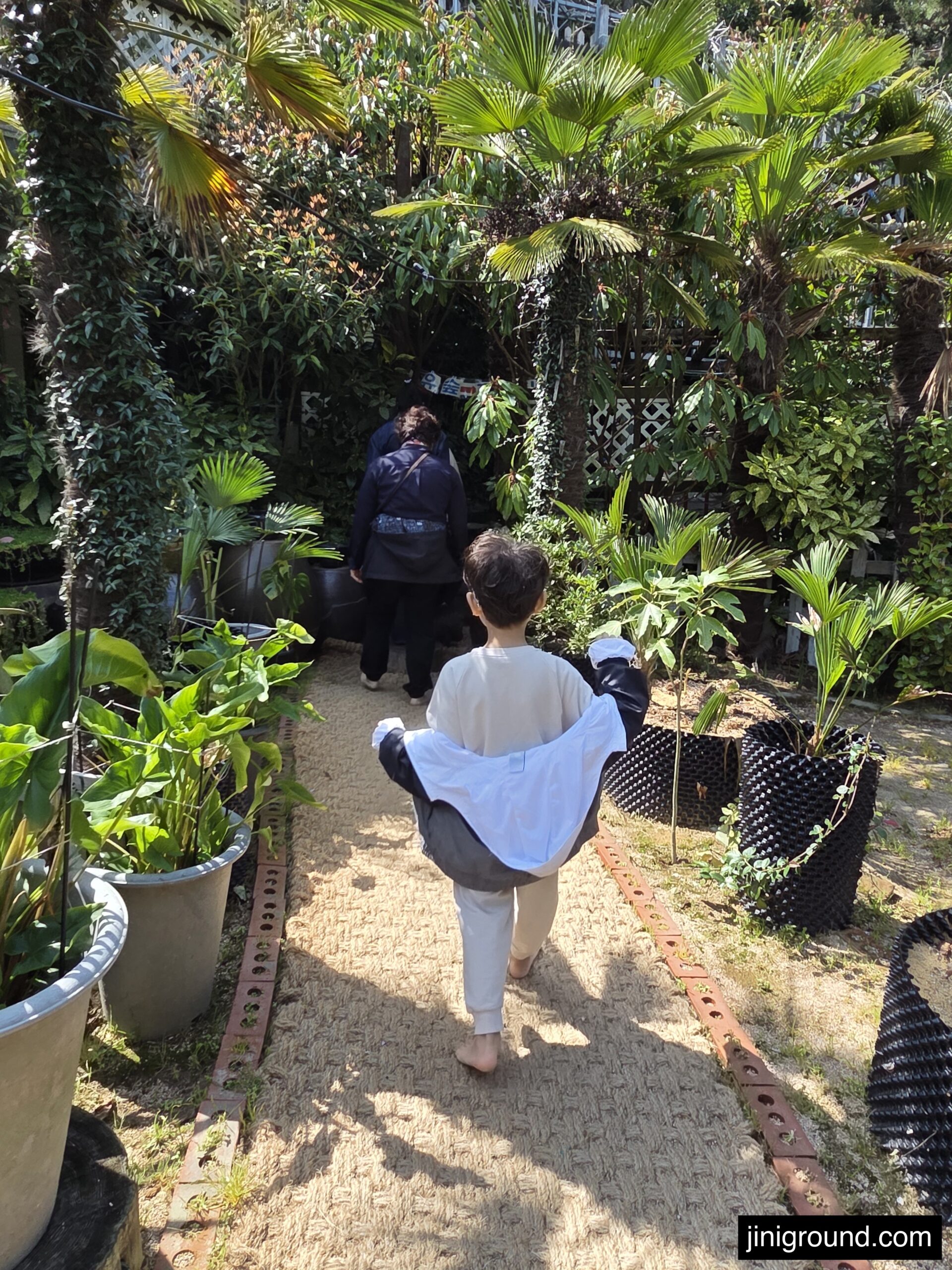 dad and son walking barefoot on garden path at Napoli Farm Tongyeong
