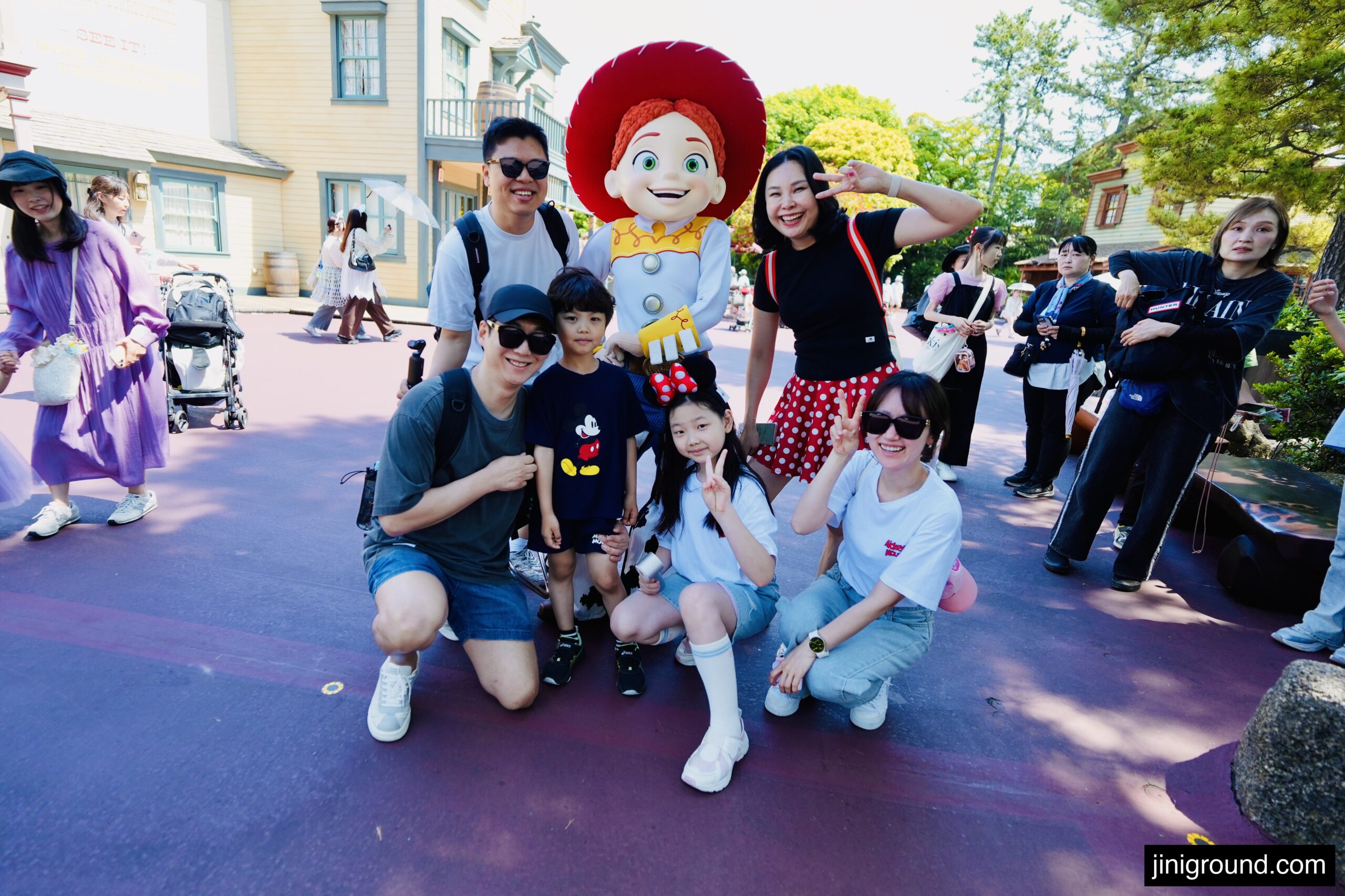 Family taking a photo with Jessie character on Main Street at Tokyo Disneyland with kids