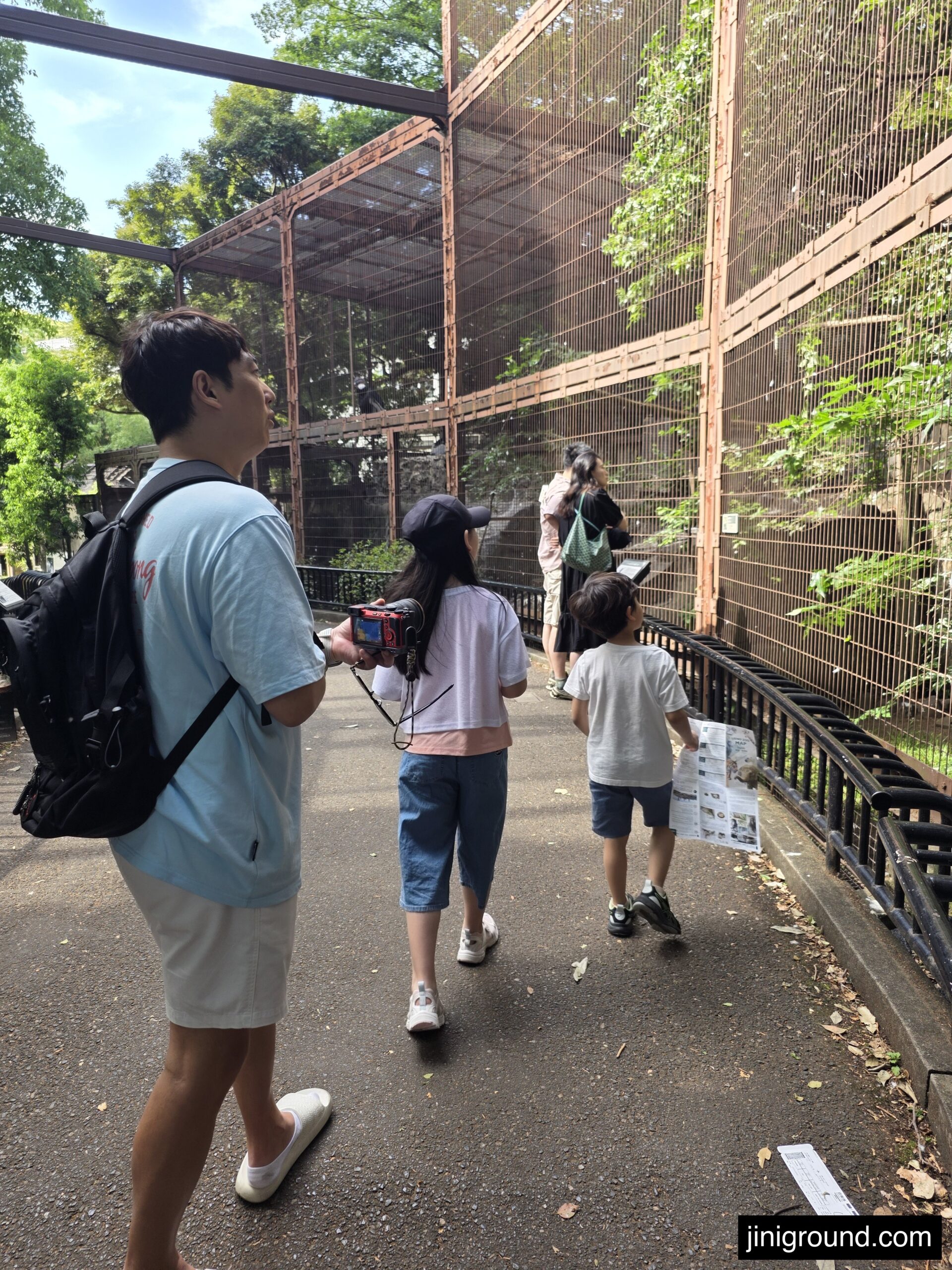 Family walking with kids past animal enclosure at Ueno Zoo Tokyo