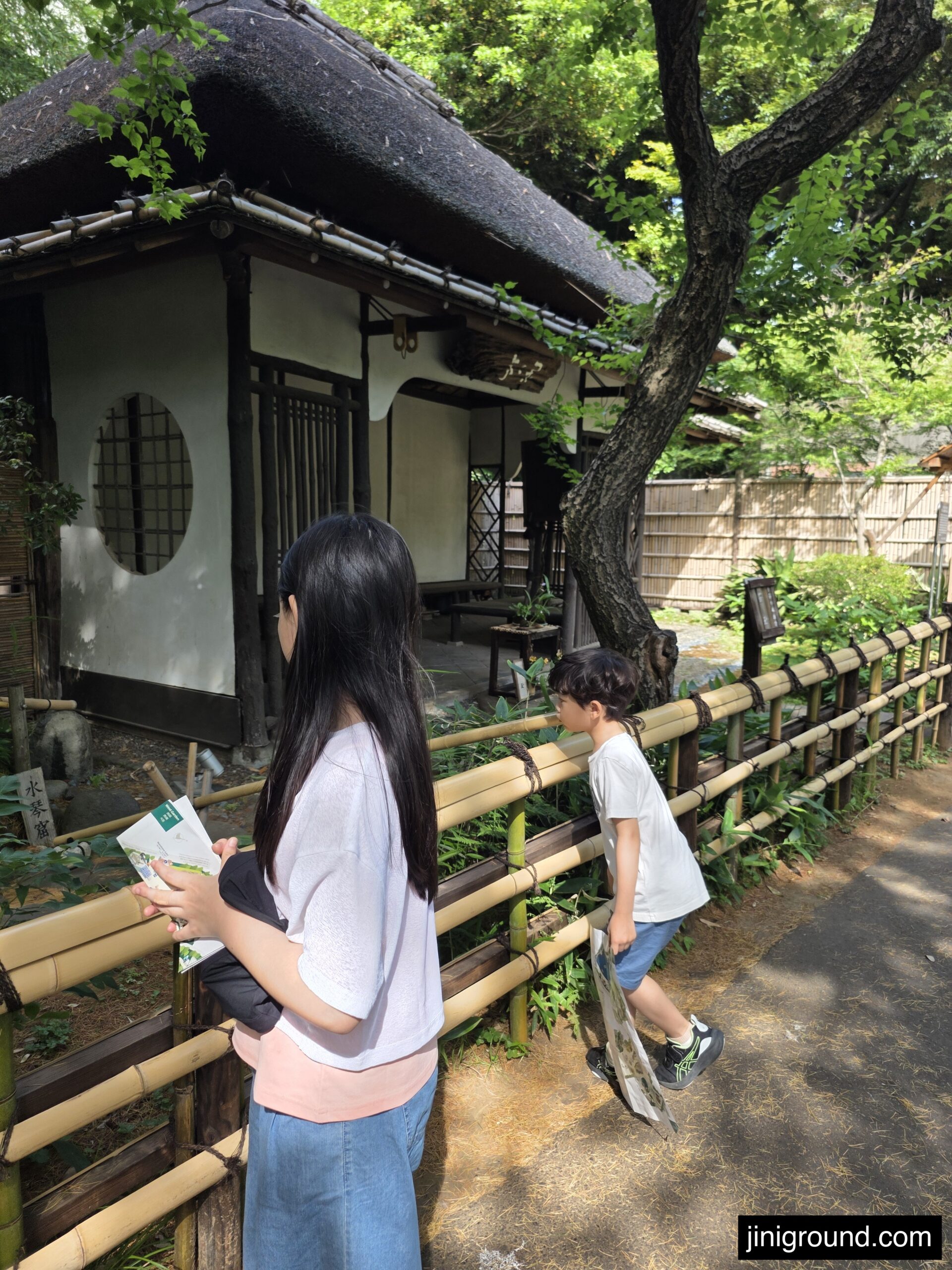 Children exploring traditional Japanese garden hut inside Ueno Zoo Tokyo