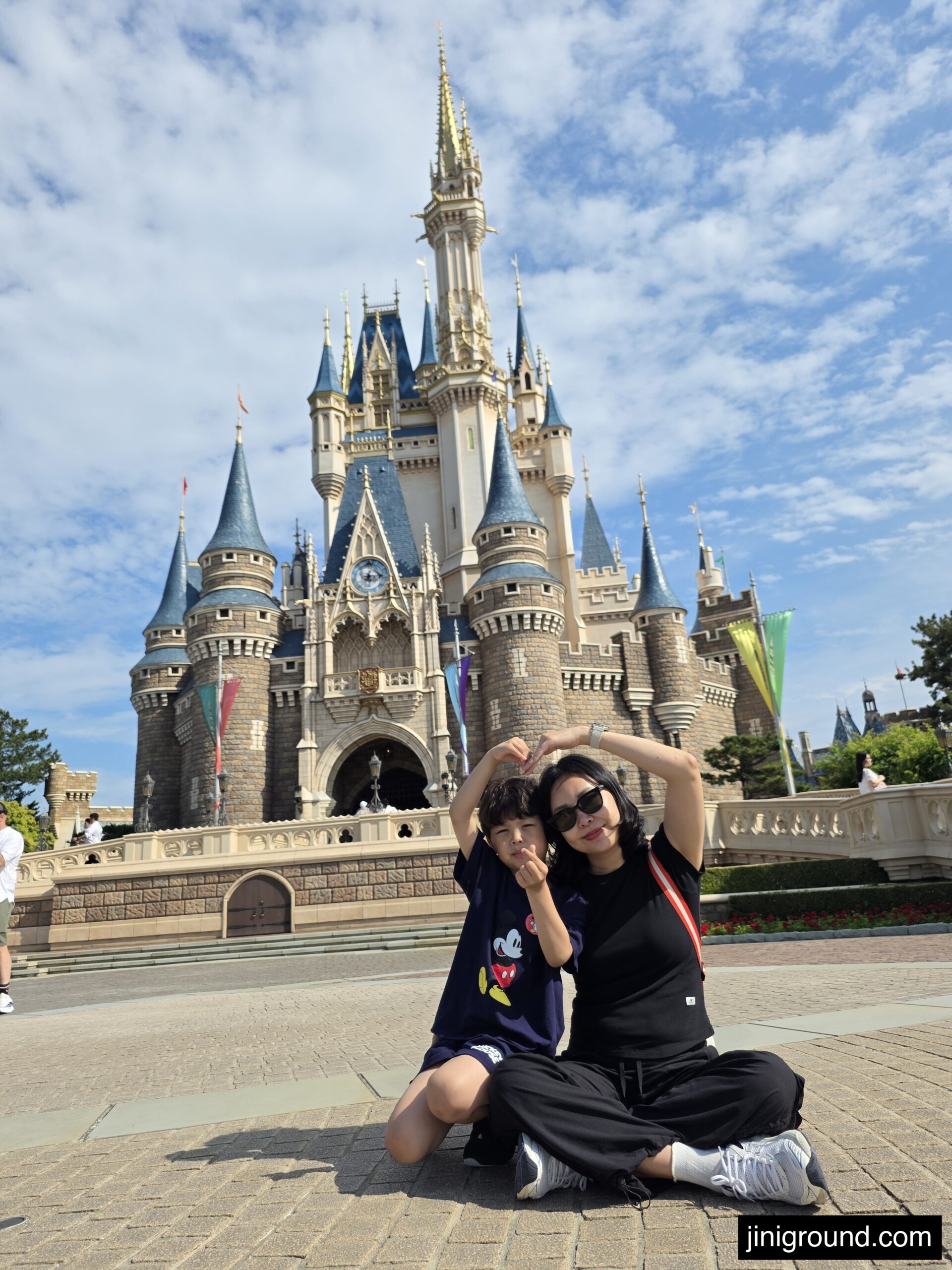 Mother and son sitting near Cinderella Castle at Tokyo Disneyland Japan
