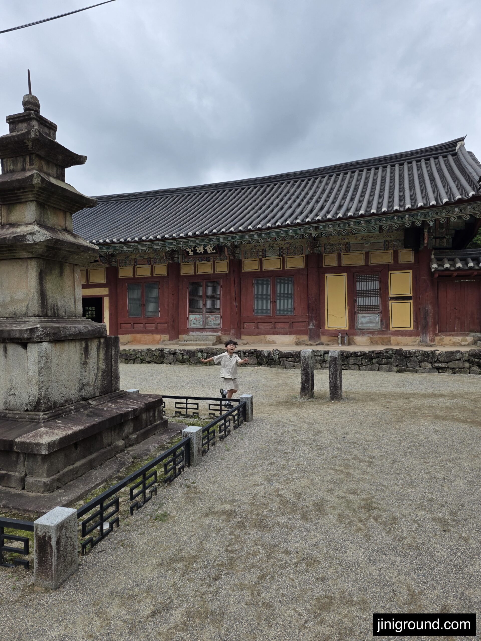 7-year-old boy walking near traditional temple building at Seonamsa Temple Suncheon