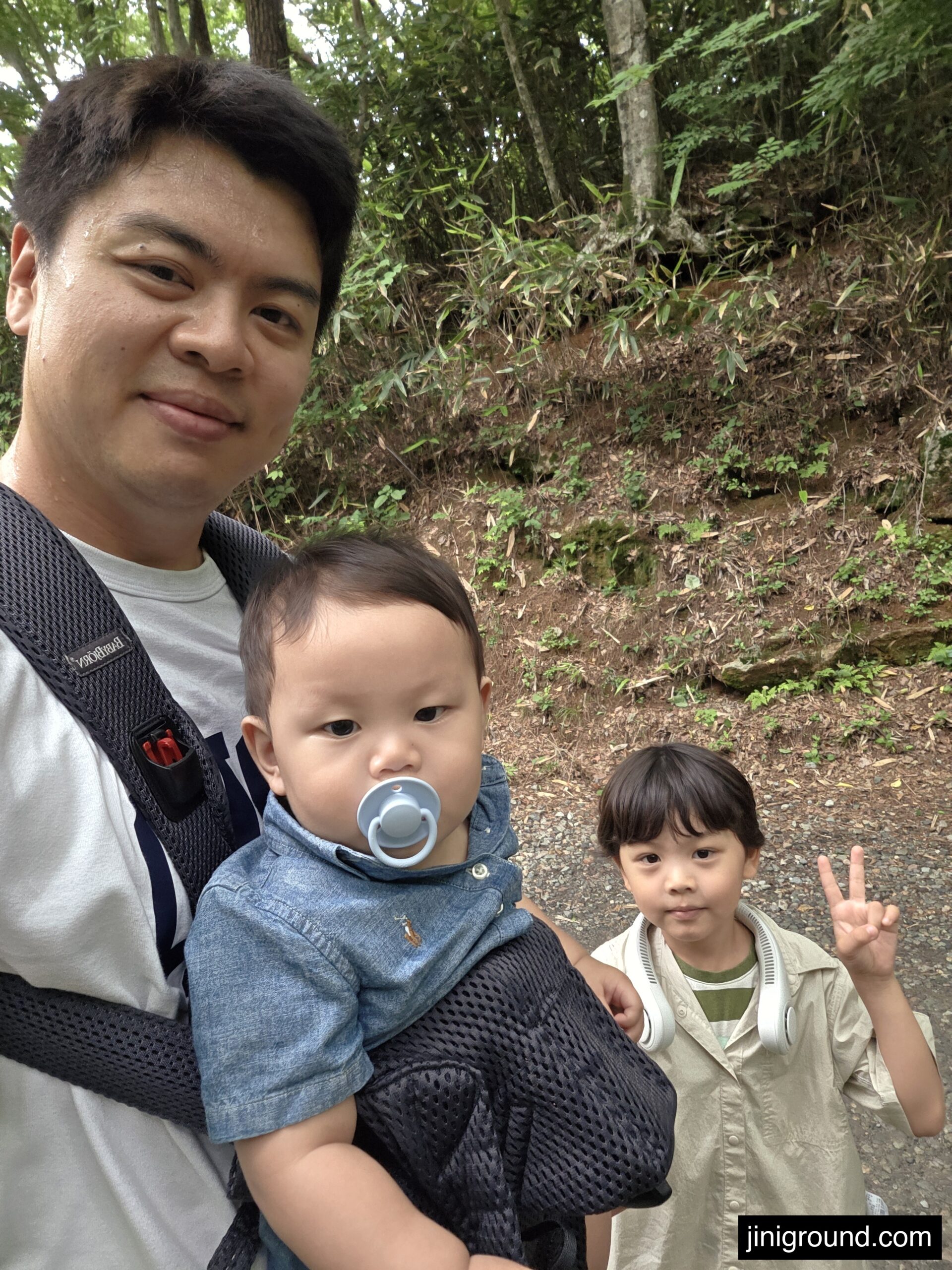 Father carrying baby in carrier while hiking trail to Seonamsa Temple with son in stroller