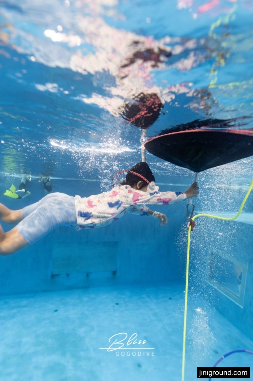 7-year-old boy freediving underwater toward a buoy at Osan theme diving pool Korea