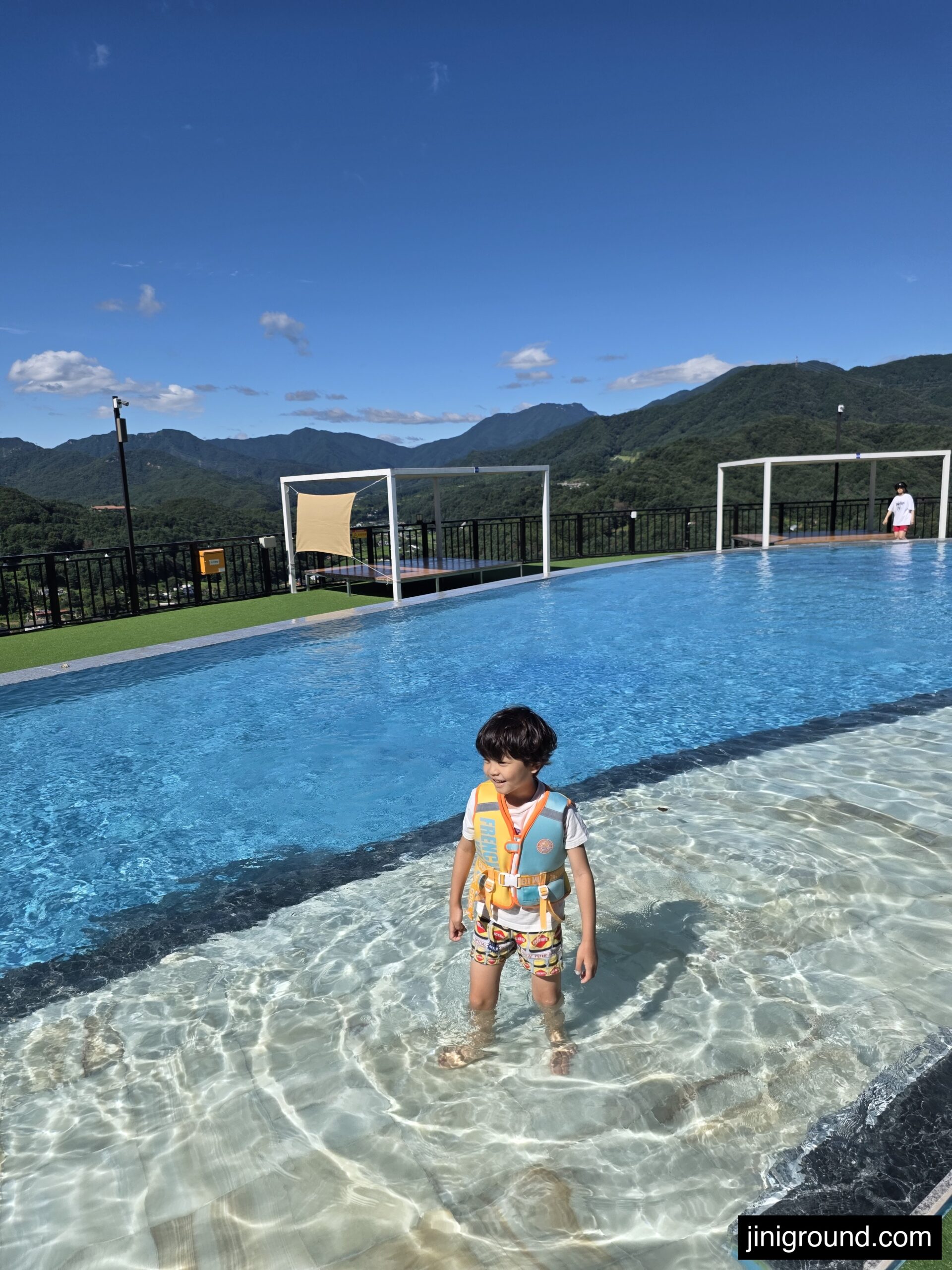 Child in a life vest standing in the shallow end of the Gapyeong pool villa outdoor pool